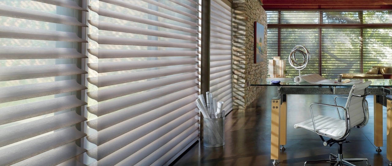 Modern office with cement floors and floor to ceiling Silhouette window treatments